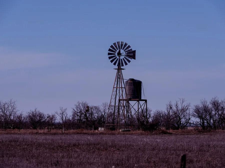 A windmill and water tower at dusk near Abilene