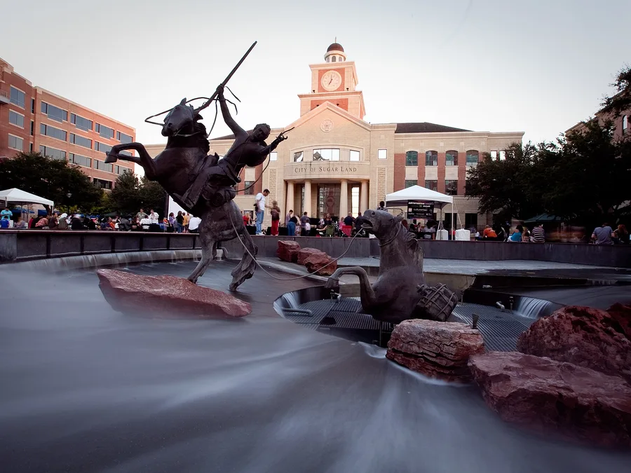 The fountain at Sugar Land Town Square with City Hall behind it